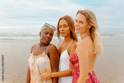 on-camera portrait of a group of three female friends with different skin tones spending a day at the beach during the summer. Diversity and friendship.