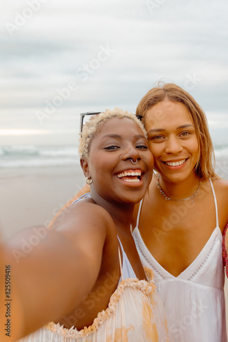 Two girls taking a selfie with their smartphone on the beach. summer travel