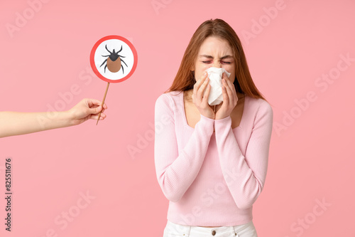 Bilde på lerret Woman with napkin suffering from allergy and female hand with mite sign on pink