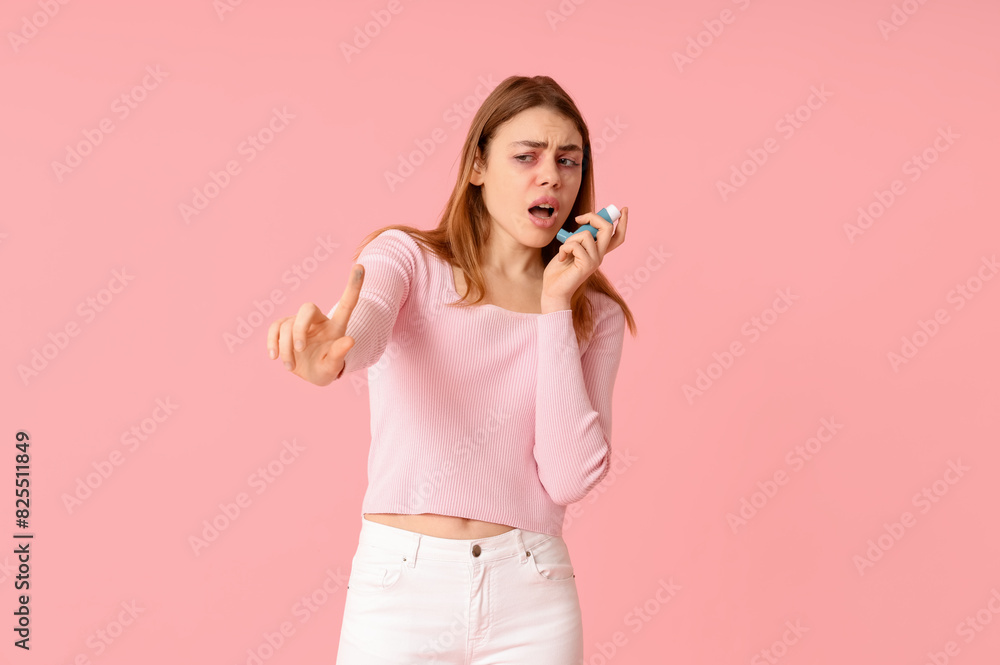 Woman with inhaler having asthma attack on pink background Woman with inhaler having asthma attack on pink background