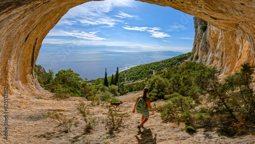 Photos Young lady hiking with her dog through scenic mountain hollow with amazing view of coast and Adriatic Sea