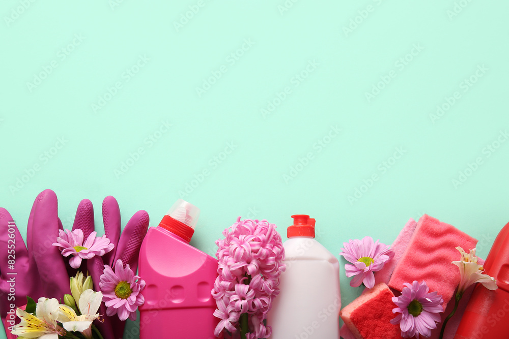 Set of cleaning supplies and spring flowers on turquoise background Set of cleaning supplies and spring flowers on turquoise background