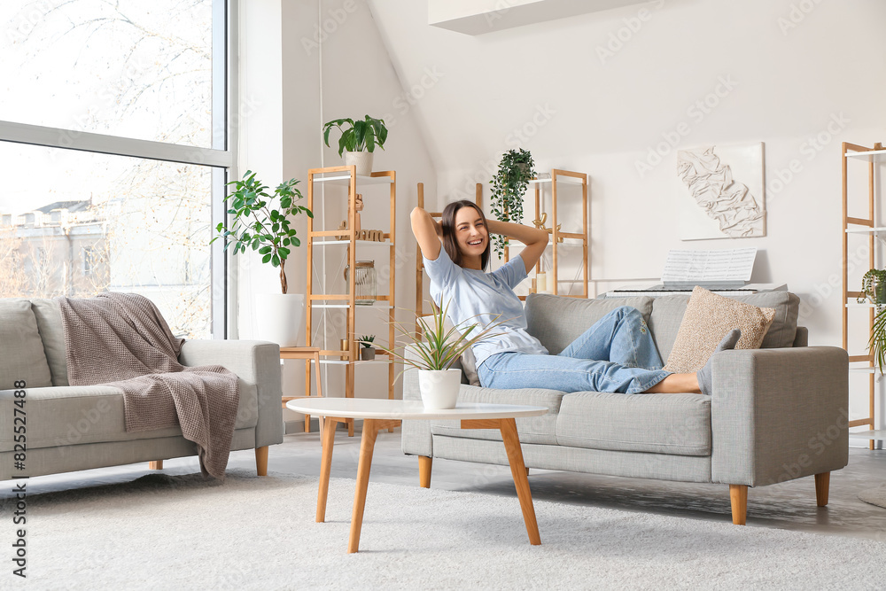 Young beautiful woman resting on cozy sofa in living room Young beautiful woman resting on cozy sofa in living room