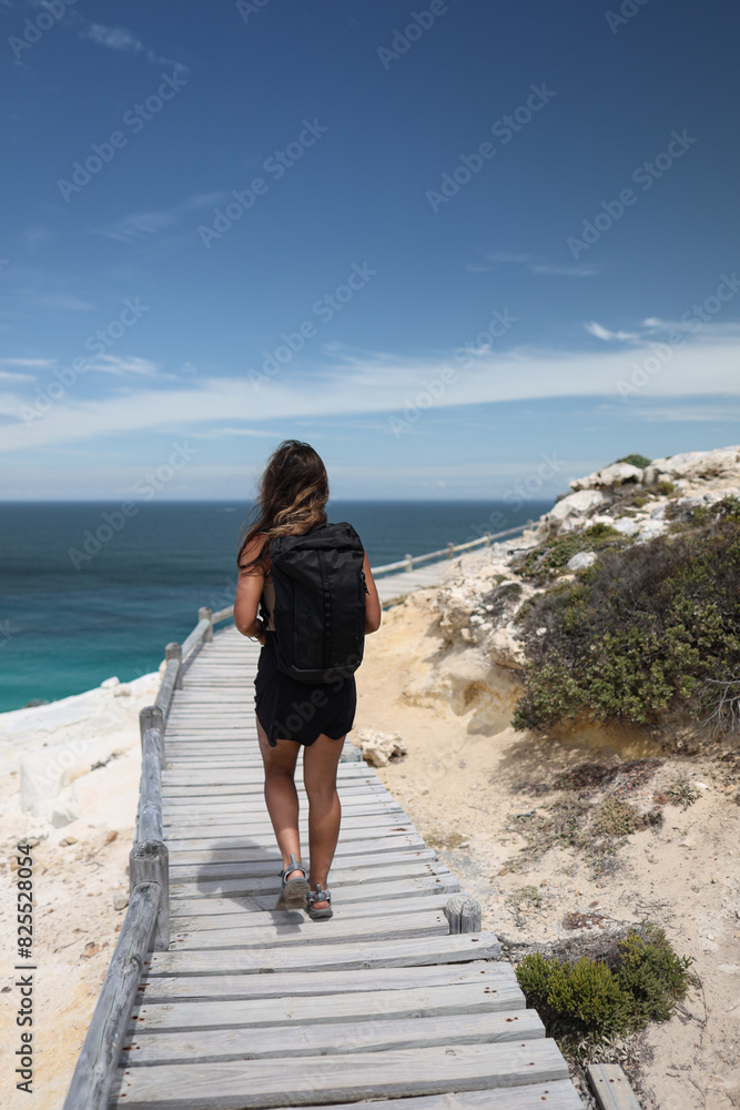 Woman standing on mountain top looking at view Woman standing on mountain top looking at view