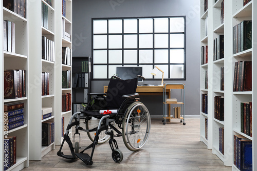 Wheelchair with diploma and graduation hat in library
