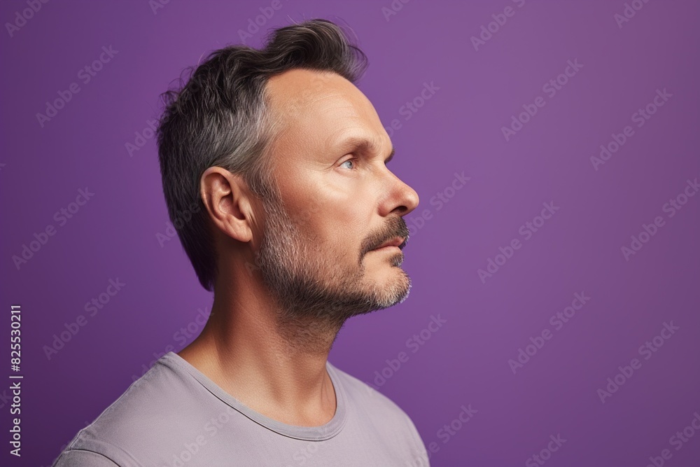 Fototapeta premium A man with a beard and gray hair is looking at the camera