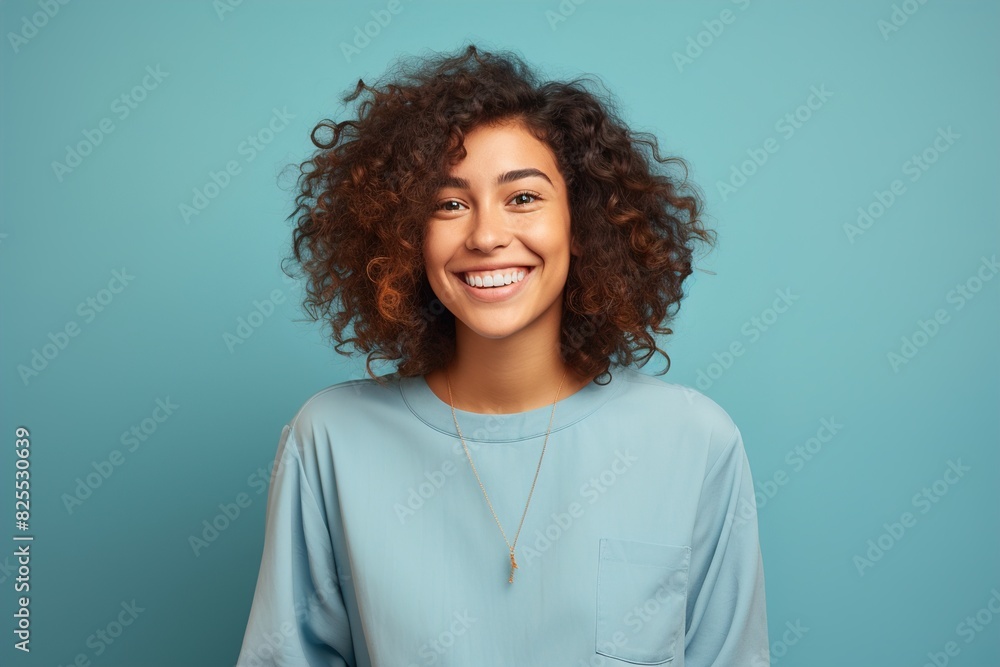 A woman with curly hair is smiling and wearing a blue shirt A woman with curly hair is smiling and wearing a blue shirt