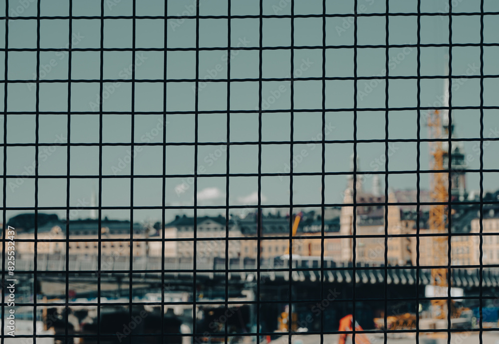 Obraz premium Close up of a fence against a cityscape