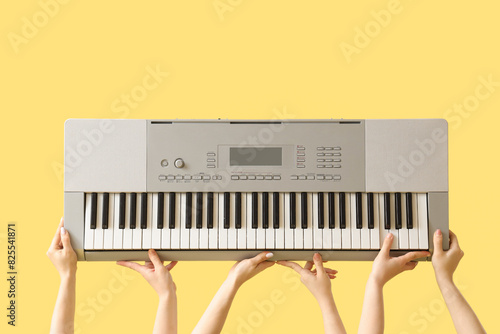 Women with synthesizer on yellow background photo