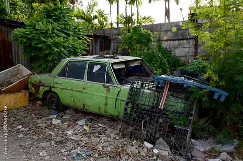 BANGKOK, THAILAND - May 23, 2024: Old car parked for a long time beside the road in Thailand.