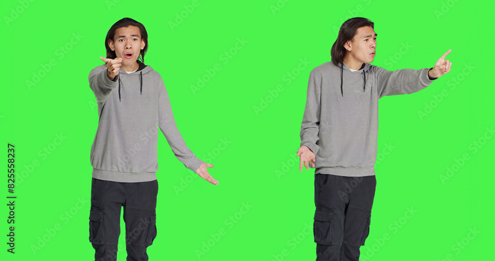 Young man showing no gesture in studio, expressing negativity and disagreement over isolated greenscreen backdrop. Asian male model being disappointed and disapproving with something. Young man showing no gesture in studio, expressing negativity and disagreement over isolated greenscreen backdrop. Asian male model being disappointed and disapproving with something.