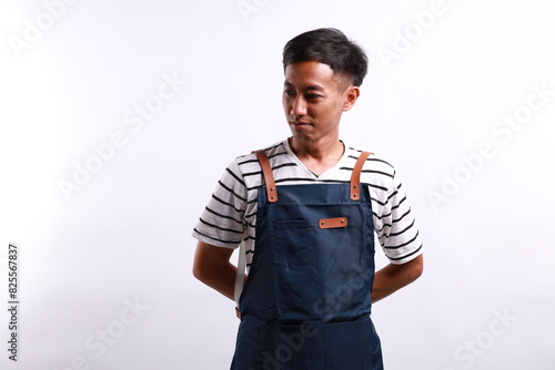 Young asian chef or waiter wearing blue apron isolated on white background photo