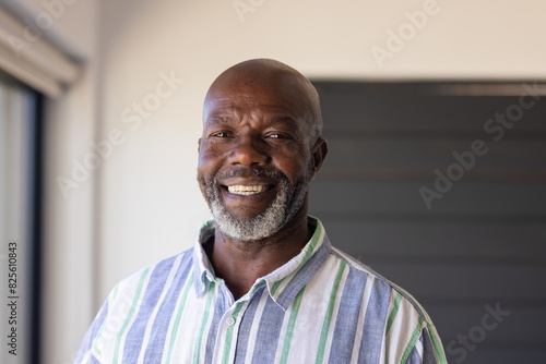 An African American senior male, wearing striped shirt, smiling at home photo
