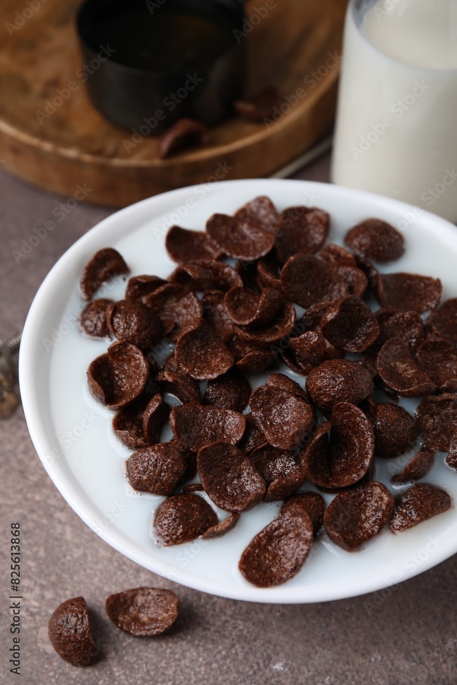 Breakfast cereal. Chocolate corn flakes and milk in bowl on brown table, closeup Breakfast cereal. Chocolate corn flakes and milk in bowl on brown table, closeup