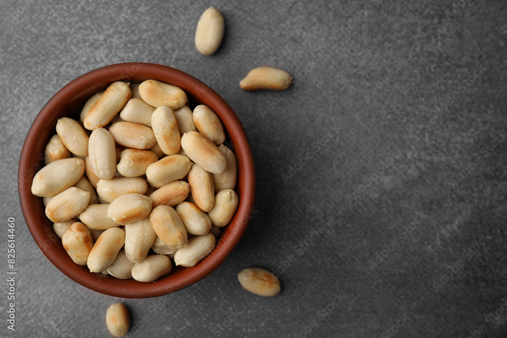 Roasted peanuts in bowl on brown table, top view. Space for text Roasted peanuts in bowl on brown table, top view. Space for text