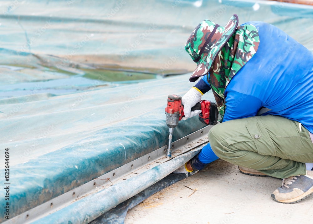 Worker use cordless screwdriver tighten nut. Worker use cordless screwdriver tighten nut.