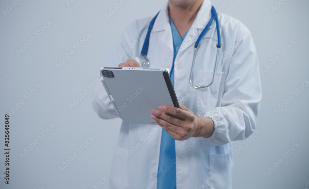 Mature male doctor with tablet pc is giving presentation. Blurred background indoors. Mature male doctor with tablet pc is giving presentation. Blurred background indoors.