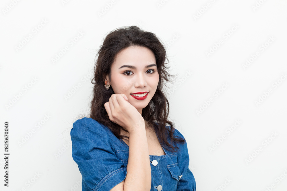 A beautiful woman with curly hair in a denim skirt on a solid background A beautiful woman with curly hair in a denim skirt on a solid background