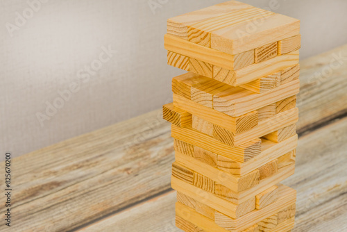 Closeup of tower of wooden blocks on a wooden tabletop. Generic version of popular game.