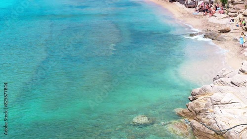 Paraside Beach in Mikonos, Greece, umbrella and luxury beach chairs beds in front of blue ocean. Most famous beach with crystal water and beach music bars. Gimbal cinematic ProRes graded from Log photo