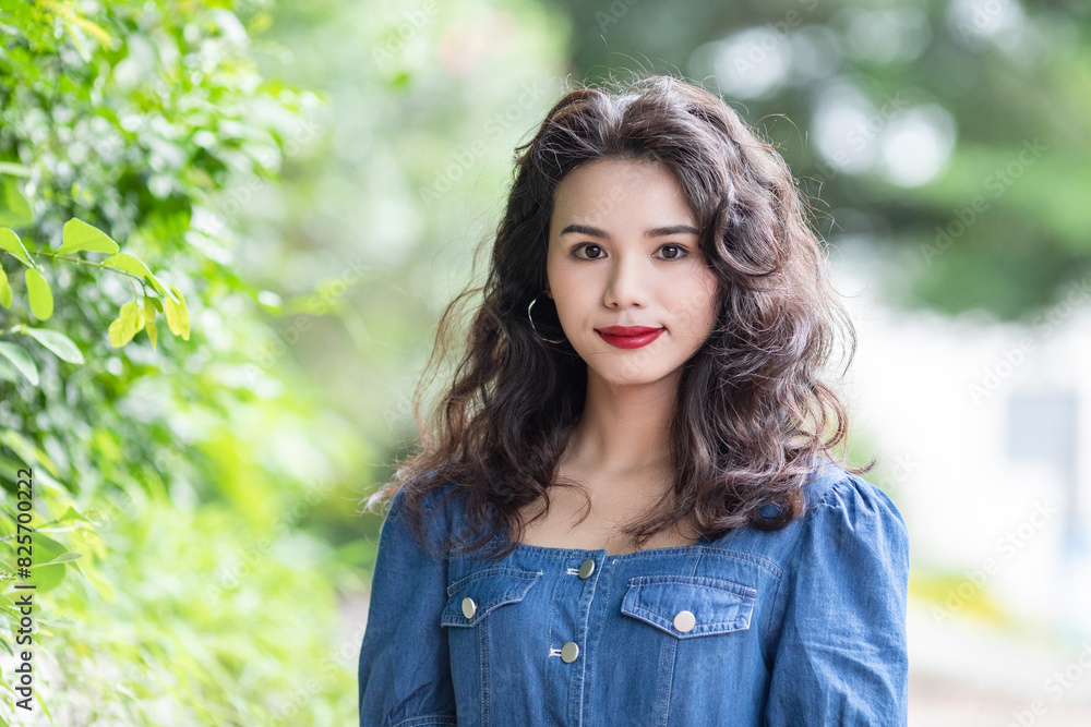 Outdoors a curly-haired Chinese beauty in a denim skirt Outdoors a curly-haired Chinese beauty in a denim skirt