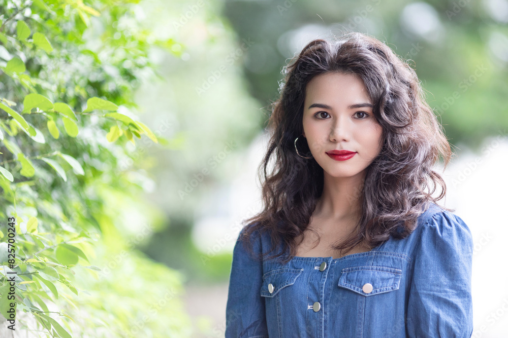 Outdoors a curly-haired Chinese beauty in a denim skirt Outdoors a curly-haired Chinese beauty in a denim skirt