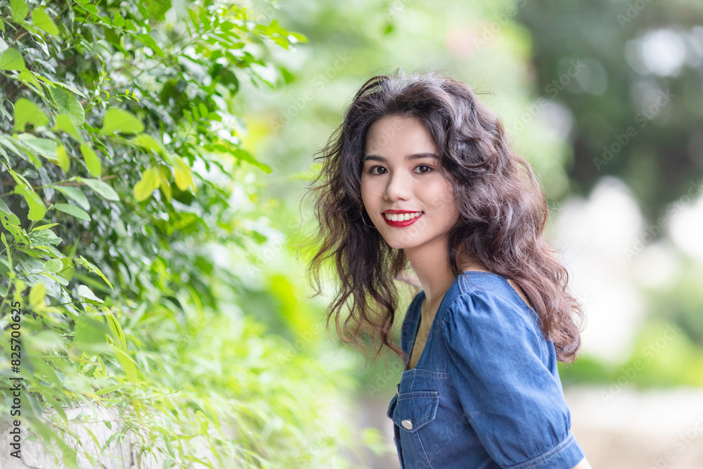 Outdoors a curly-haired Chinese beauty in a denim skirt Outdoors a curly-haired Chinese beauty in a denim skirt