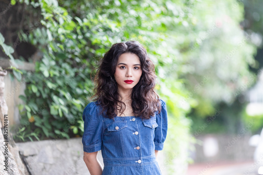 Outdoors a curly-haired Chinese beauty in a denim skirt Outdoors a curly-haired Chinese beauty in a denim skirt