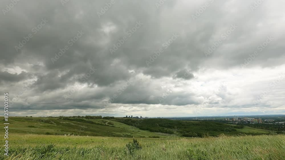 Stormy clouds travel fast above green hill grassland or parks in Alberta Canada. timelapse rainy season wet weather in the summer. beautiful landscape background of the nature. Amazing God's creation Stormy clouds travel fast above green hill grassland or parks in Alberta Canada. timelapse rainy season wet weather in the summer. beautiful landscape background of the nature. Amazing God's creation