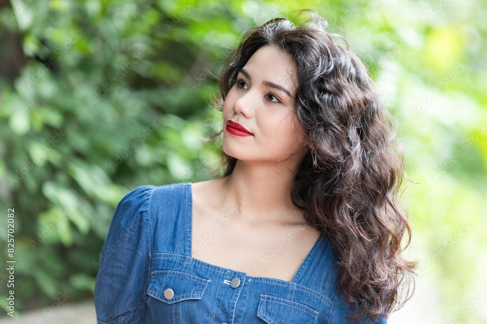 Outdoors a curly-haired Chinese beauty in a denim skirt Outdoors a curly-haired Chinese beauty in a denim skirt