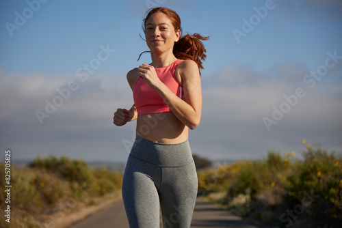 Redhead woman running outdoors.