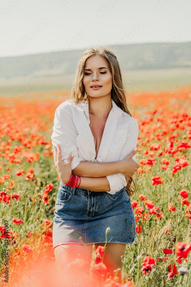 Happy woman in a poppy field in a white shirt and denim skirt with a wreath of poppies on her head posing and enjoying the poppy field. Happy woman in a poppy field in a white shirt and denim skirt with a wreath of poppies on her head posing and enjoying the poppy field.