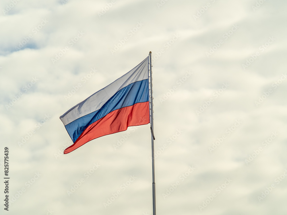 Russian tricolor flag waving in the wind against a blue sky. Russian tricolor flag waving in the wind against a blue sky.