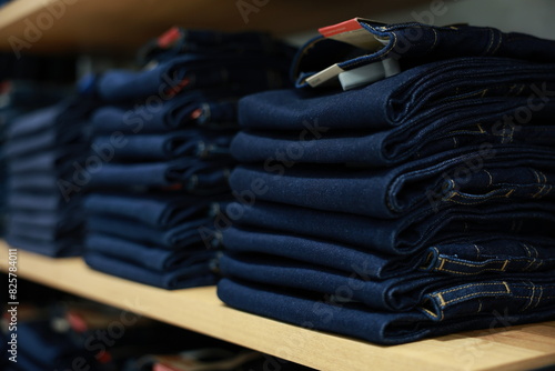 Many jeans in closet. Stack of jeans on shelf. Concept of buy , sell , shopping and jeans fashion .