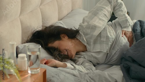 Woman lying on bed touch stomach pain menstrual period girl female pills medicine unhealthy poisoning ill hurting unwell abdomen bedroom body sickness ache discomfort belly hurt home painkiller drugs