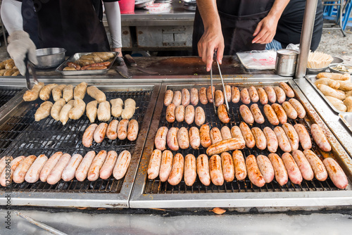 Close-up of the vendors are grilling Taiwanese sausage and sticky rice (glutinous rice) sausage in the night market of Taiwan. This is one of the street snacks popular among tourists in Taiwan.