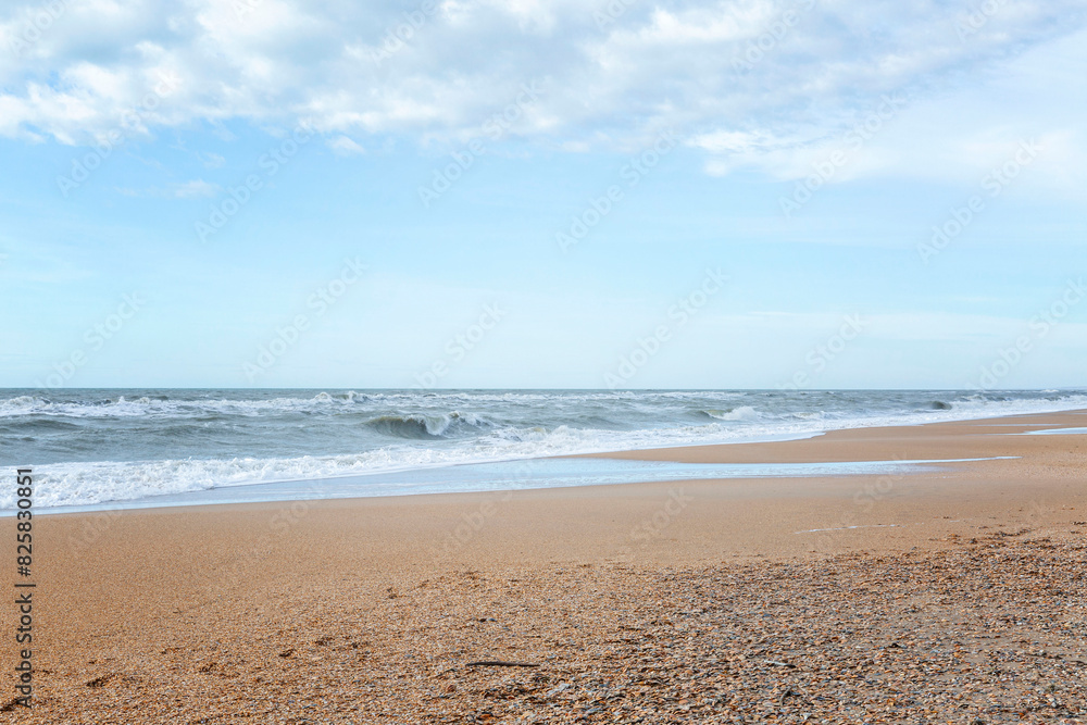 Sandy shore of a calm sea. Blue sky and beautiful landscape. Tourism and travel. Sandy shore of a calm sea. Blue sky and beautiful landscape. Tourism and travel.