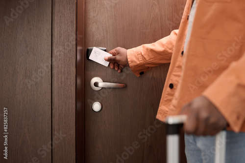 Close up of guest opening hotel room door and pressing keycard to NFC security lock system copy space photo