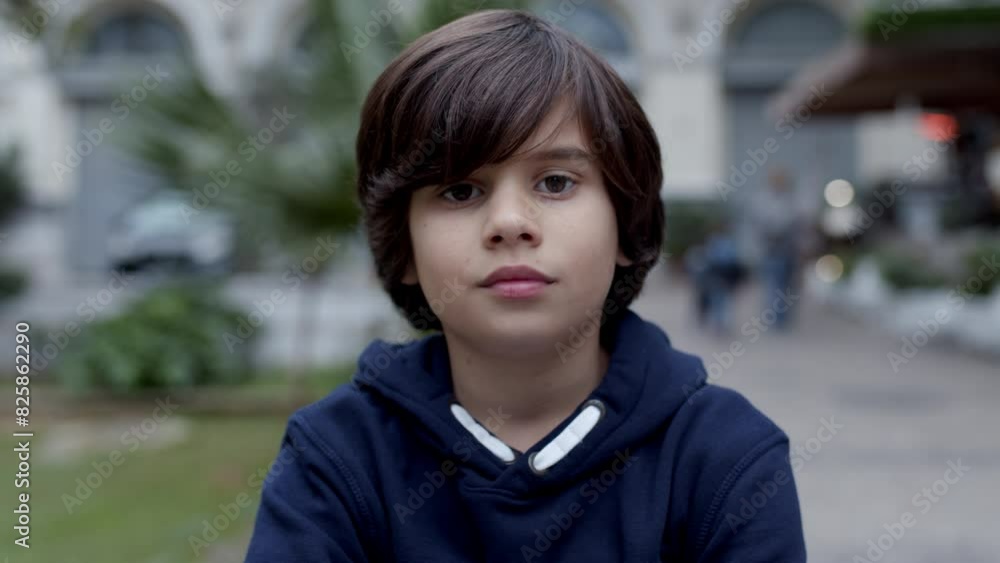 A young boy in a blue hoodie is gazing at the camera. He has a pleasant smile. The boys features include nose, eye, jaw, bangs, and black hair. His attire is an electric blue jacket A young boy in a blue hoodie is gazing at the camera. He has a pleasant smile. The boys features include nose, eye, jaw, bangs, and black hair. His attire is an electric blue jacket