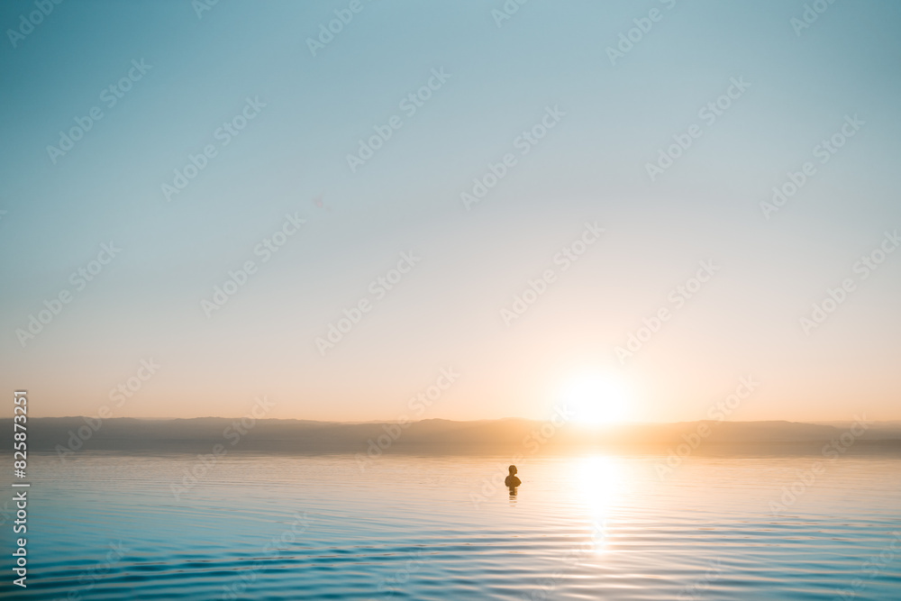 Woman Swimming in the Dead Sea at Sunset, JordanConcept woman on the beach with a sunset. Woman Swimming in the Dead Sea at Sunset, JordanConcept woman on the beach with a sunset.