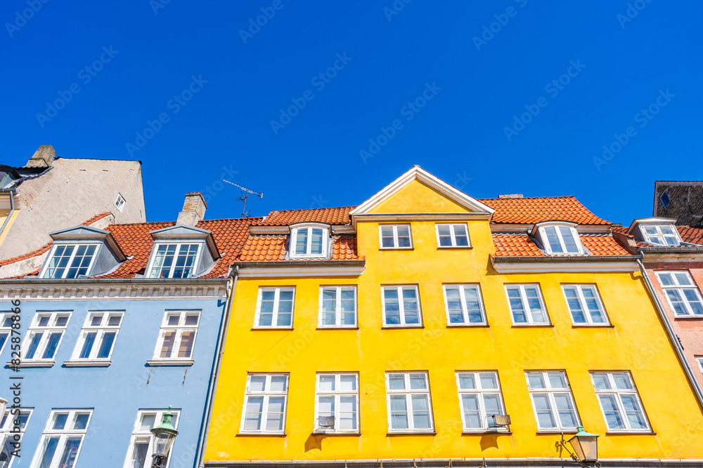Fototapeta premium Colorful facades of old houses along Nyhavn embankment in Copenhagen - upward view. Denmark