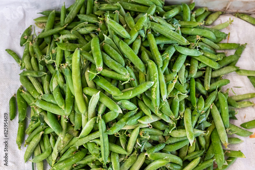 Snow peas at the market. Green peas in the close-up. Fresh organic snow peas for sale at Sunday farm market.