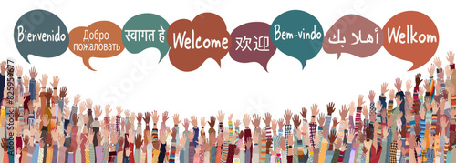 Hand raised of multicultural people from different nations and continents with speech bubbles with text -Welcome- in various international languages.Communication.Community. Diversity