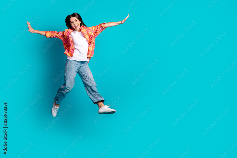 Full size photo of nice young girl jump fly empty space wear plaid shirt isolated on teal color background