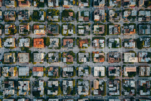 Top-down aerial view of a city grid  focusing on the symmetry and repetitive patterns of streets and buildings. 