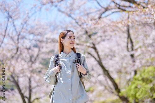 春の桜とインバウンドバックパッカーの女性