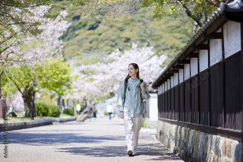 春の観光地を歩くインバウンド旅行者の女性