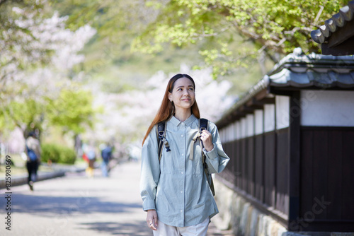 春の観光地を歩くインバウンド旅行者の女性