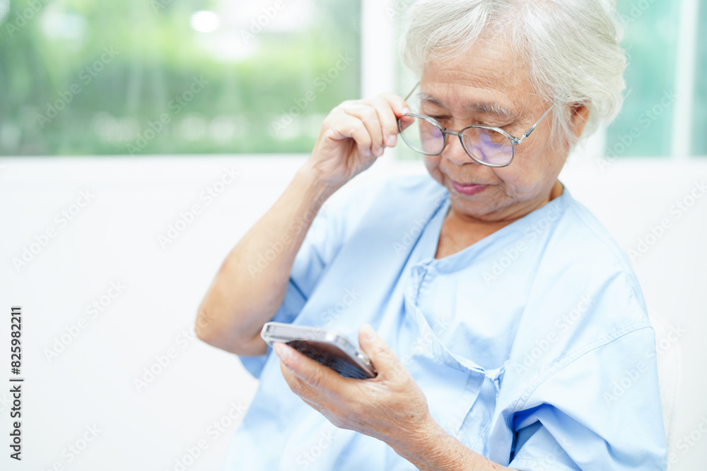 Asian senior woman wearing eyeglasses or vision glasses using a smartphone at home care service. Asian senior woman wearing eyeglasses or vision glasses using a smartphone at home care service.