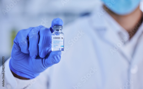 Person, hand and vaccine bottle in clinic for treatment or illness control for virus, disease and innovation. Medical worker, booster and shot for immunization, prevention and cure for covid 19.